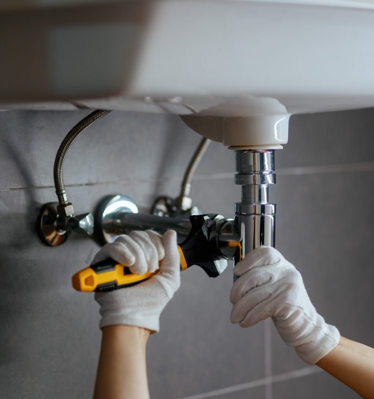 Sanitärarbeiten an einem Waschbecken durch einen professionellen Installateur